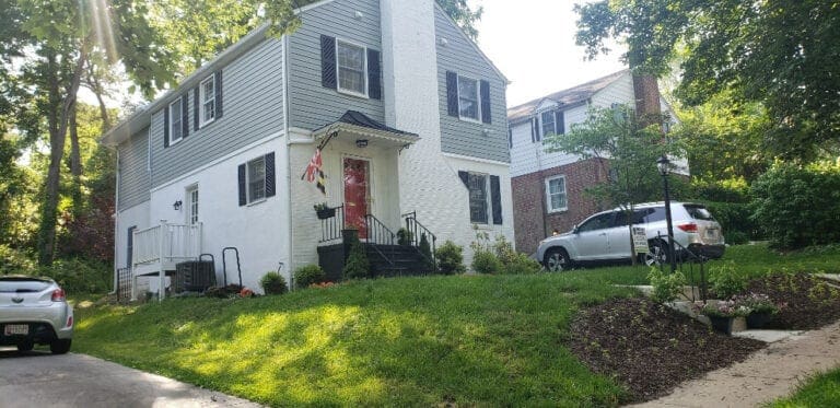 White seamless gutters on a gray and white two-story house