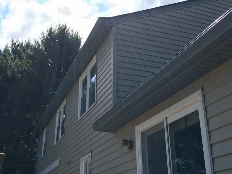 New soffit and fascia under the roof overhang of a gray two-story home in Northern Virginia