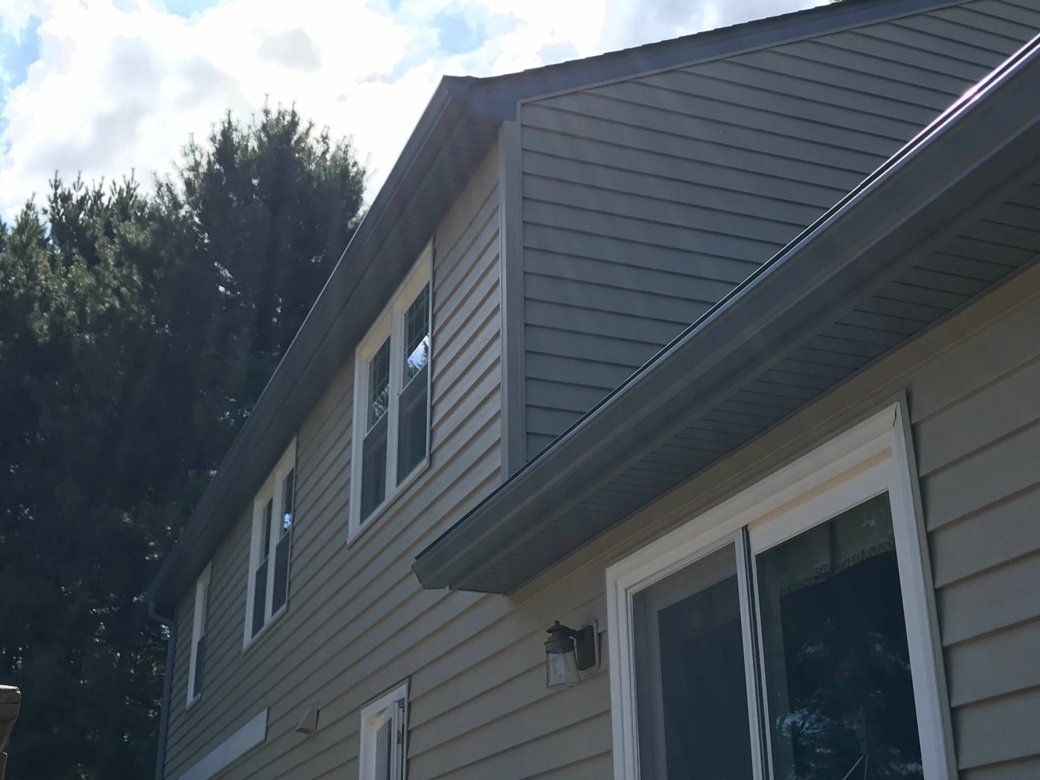 Two-story Northern Virginia home with gray siding, new soffit and gutters along the roofline