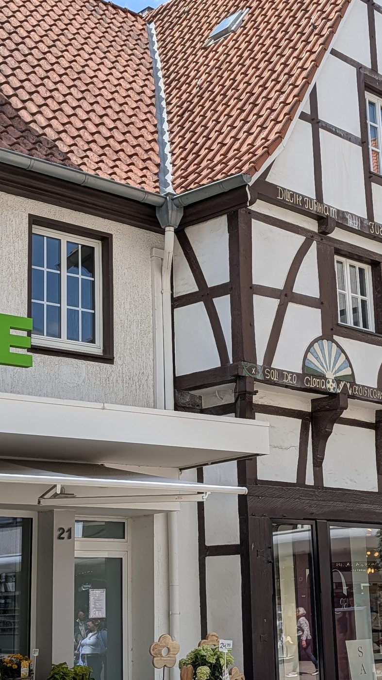 Half round gutter and round downspout on an old European half-timbered home with clay tile roof